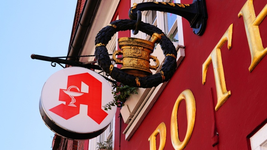 Apotheke mit Zunftzeichen und modernen Logo